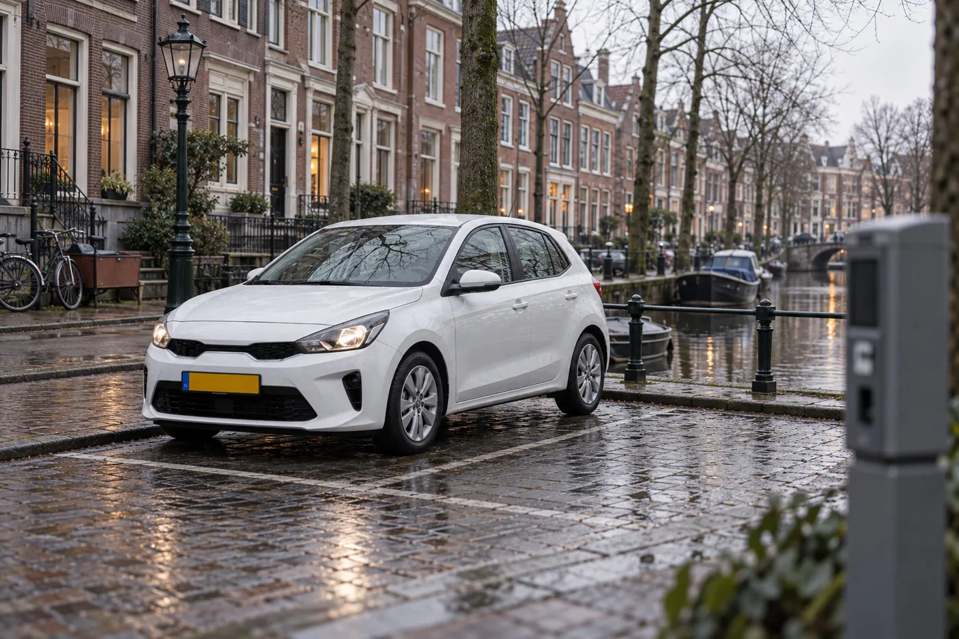 A white hatchback parked beside a canal, next to a parking terminal